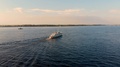 Aerial Chase Of The Ship Sailing On The Sea To The Wooded Shore. Taken By Drone