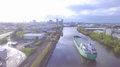 Aerial Drone Shot Circling Haulage Ship Passing Green Landscape