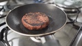 Burned Vegan Plant Based Burger Cooking On Frying Pan In Slow Motion
