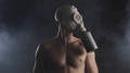 Close Up Portrait Of A Naked Man In A Gas Mask In A Smoky Dark Room