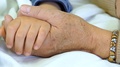Grandparent Holds A Sick Child's Hand In The Hospital. Close-Up Slider