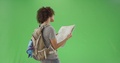 Pond5 Millennial girl reads a map while wearing her hiking backpack on green screen
