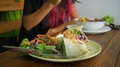 Pond5 Vegan wrap vegetable dish closeup and young girl enjoying delicious dinner at